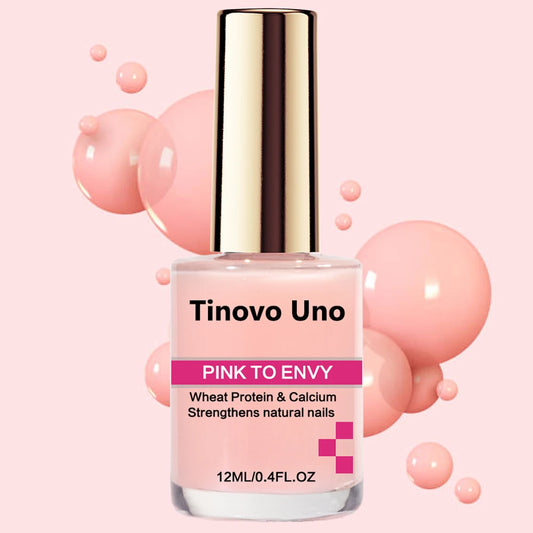 A bottle of TINOVO UNO Pink to Envy nail strengthener, which is a clear liquid with slight pink hue in a transparent bottle with a gold-colored cap. The label indicates that it is a wheat protein & calcium strengthener for natural nails and that the product size is 12ml / 0.4 FL.OZ